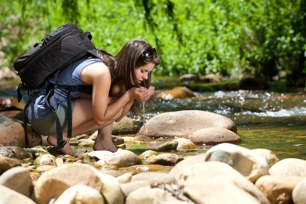 Vrouw drinkwater uit buiten stream met haar handen — Stockfoto