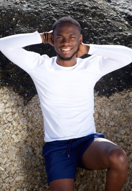 Ellerini başının arkasında ile gülümseyen yakışıklı genç