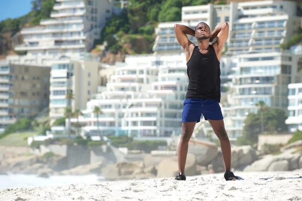 Hombre relajándose después de hacer ejercicio en la playa — Foto de Stock