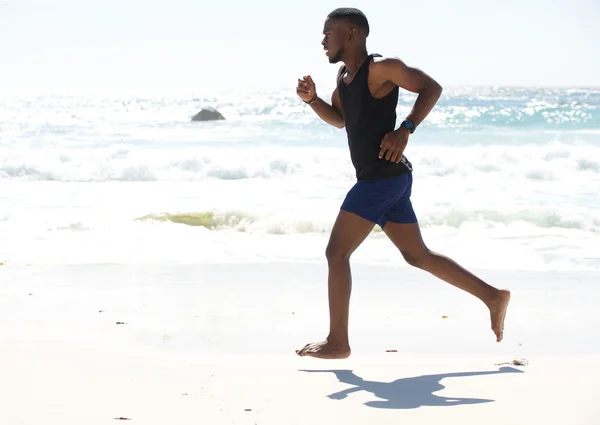 Junger Mann beim Joggen am Strand — Stockfoto