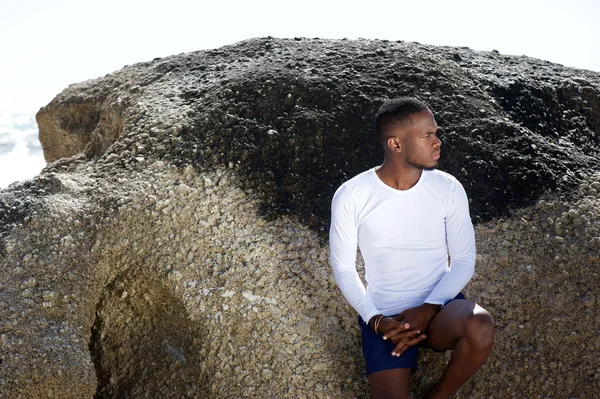 Handsome african american man leaning against rock — Stock Photo, Image
