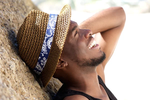 Joven alegre riendo en la playa con sombrero — Foto de Stock