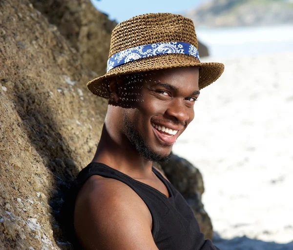 Cara legal sorrindo na praia com chapéu — Fotografia de Stock