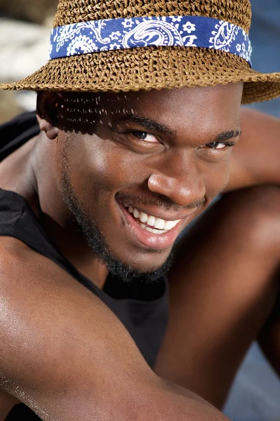 Bello giovane uomo nero sorridente con cappello — Foto Stock