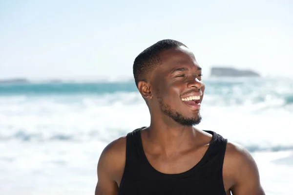 Bonito jovem afro-americano rindo da praia — Fotografia de Stock