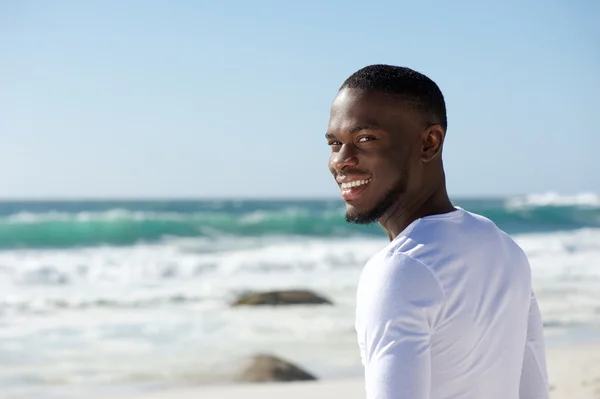 Felice sorridente uomo africano americano in spiaggia — Foto Stock