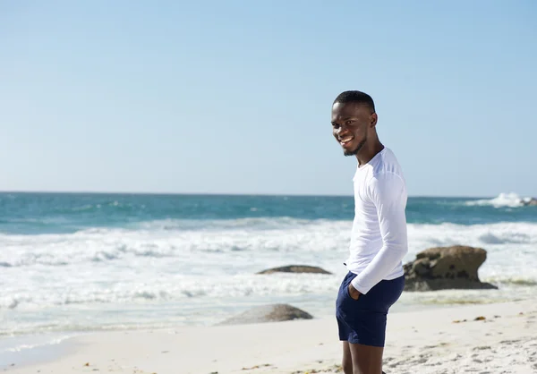 Счастливый африканский американец улыбается на пляже — стоковое фото