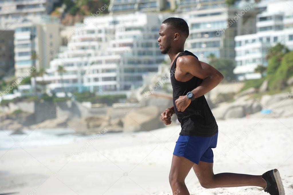 Young african american man running at the beach