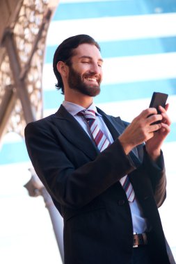 İşadamı gönderen kısa mesaj cep telefonu üzerinde gülümseyen