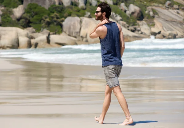 Przystojny młodzieniec spaceru sam na pustej plaży — Zdjęcie stockowe