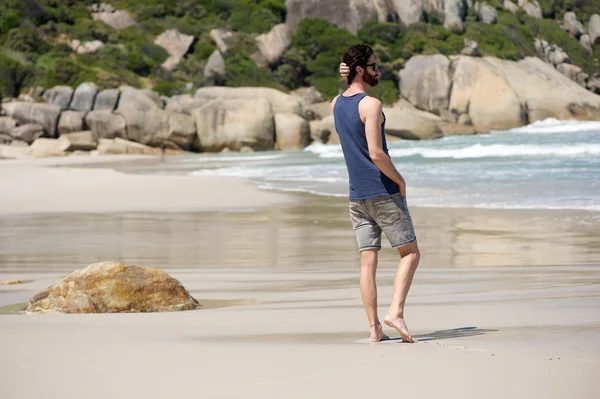 Jeune homme attrayant marchant seul sur une plage vide en été — Photo