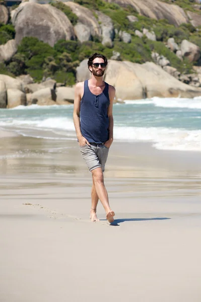 Beau jeune homme avec barbe marchant sur une plage isolée — Photo