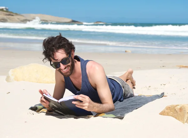 Jovem feliz lendo livro na praia — Fotografia de Stock