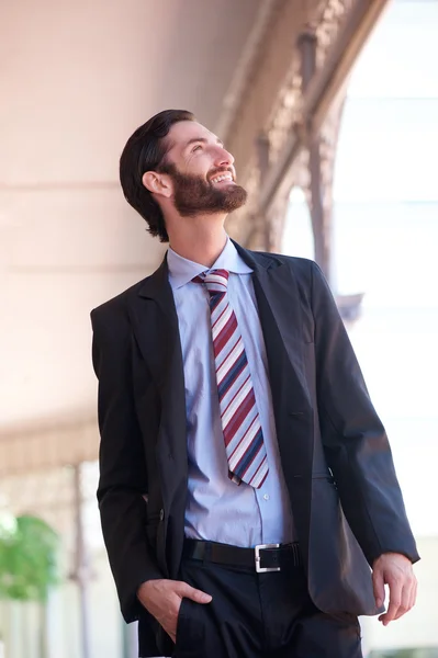 Homem de negócios moderno andando e sorrindo ao ar livre — Fotografia de Stock