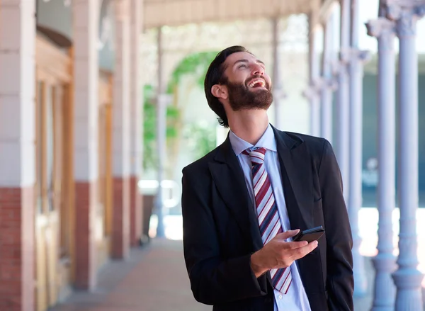 Zakenman lachen met mobiele telefoon outdoors — Stockfoto