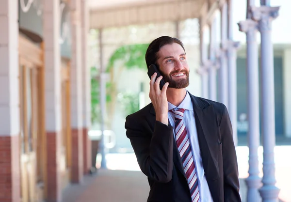 Biznesmen, uśmiechając się i rozmowy na telefon komórkowy w mieście — Zdjęcie stockowe