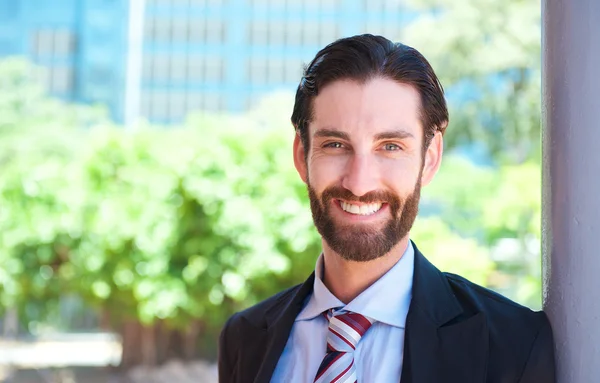 Guapo joven hombre de negocios sonriendo al aire libre — Foto de Stock