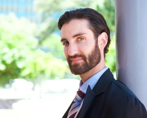 Attractive young businessman standing outdoors in suit — Stock Photo, Image