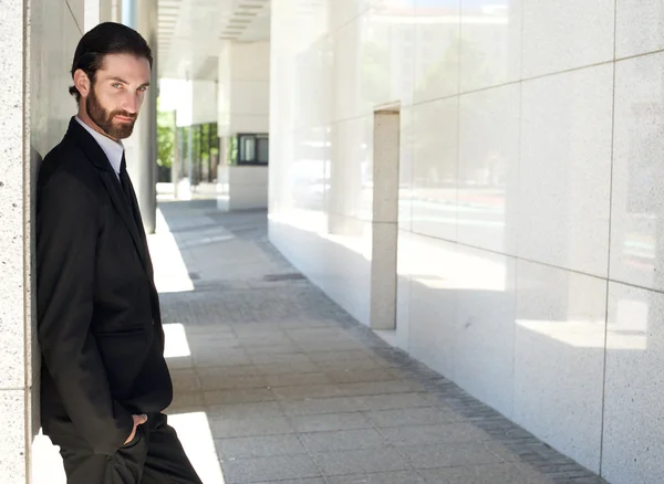 Trendiger junger Geschäftsmann steht vor Bürogebäude — Stockfoto