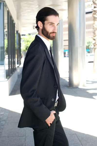 Ung affärsman går utanför i kostym — Stockfoto