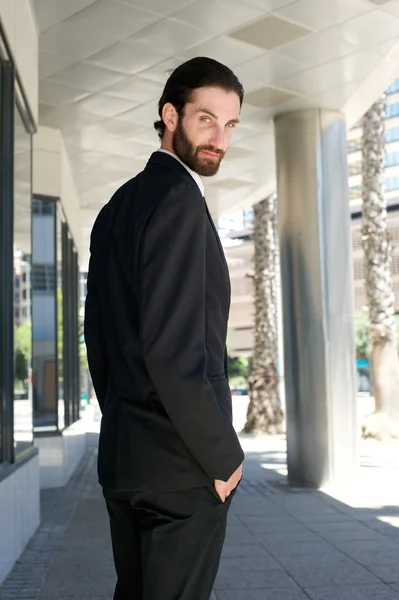 Modelo de moda masculina en traje de negocios negro de pie al aire libre — Foto de Stock