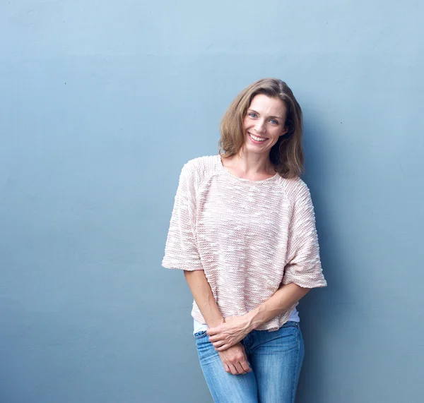 Aantrekkelijk medio volwassen vrouw die lacht op grijze achtergrond — Stockfoto