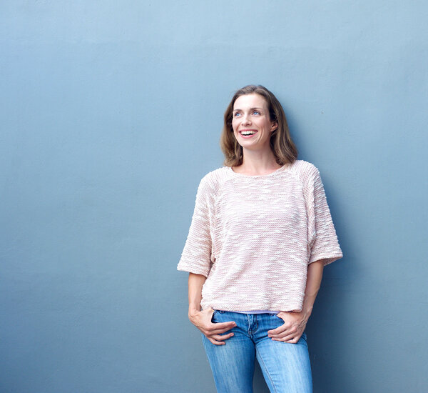 Уверенная в себе расслабленная, модная женщина средних лет улыбается
