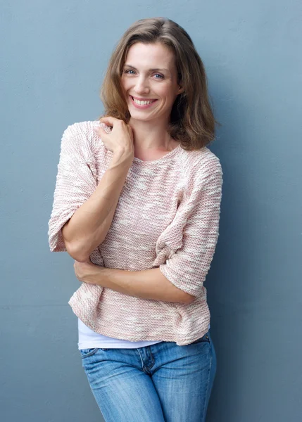 Alegre mujer adulta media sonriendo en jeans y suéter —  Fotos de Stock