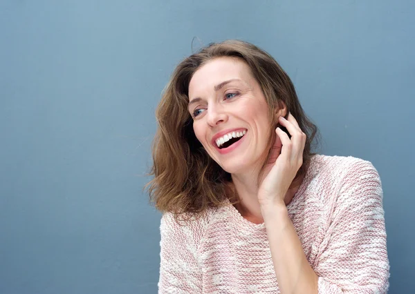 Mujer alegre riendo con la mano en el pelo — Foto de Stock