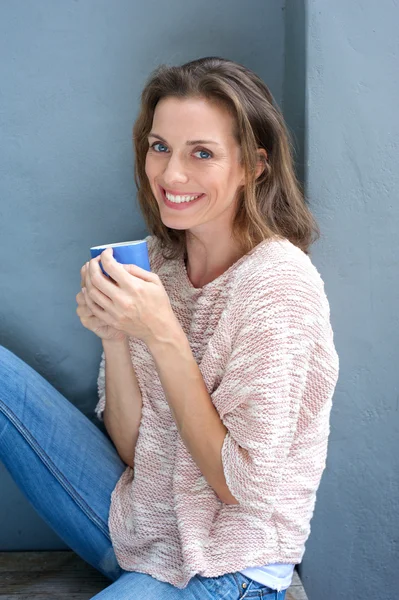 Hermosa mujer adulta mediana sonriendo con una taza de café — Foto de Stock