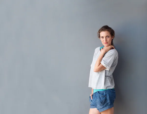 Moderna mujer adulta media posando sobre fondo gris — Foto de Stock