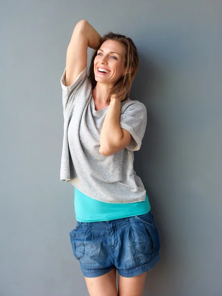 One attractive mid adult woman smiling with hands in hair — Stock Photo, Image