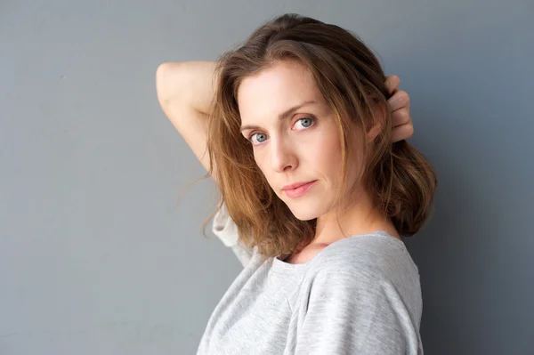 Elegant mid adult woman posing with hand in hair — Stock Photo, Image