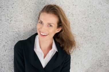 İş kadını siyah ceket ve beyaz gömlek ile gülüyor