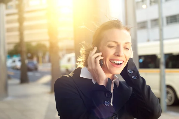 Szép üzletasszony mosolyogva a mobil telefon a szabadban — Stock Fotó