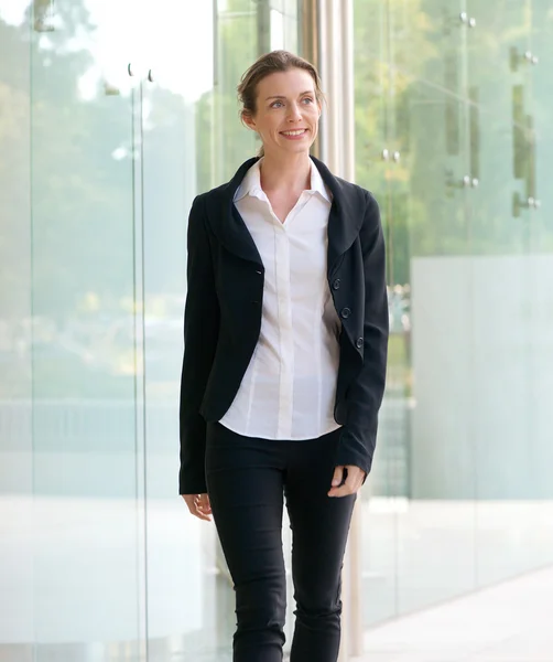 Aantrekkelijke zakenvrouw glimlachend en lopen buiten — Stockfoto
