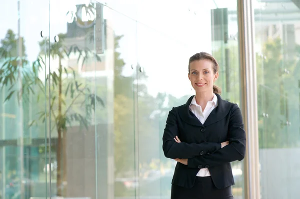 Aantrekkelijke zakelijke vrouw die lacht met gekruiste armen — Stockfoto