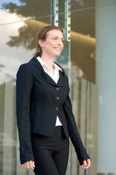 Confident business woman smiling and walking — Stock Photo, Image