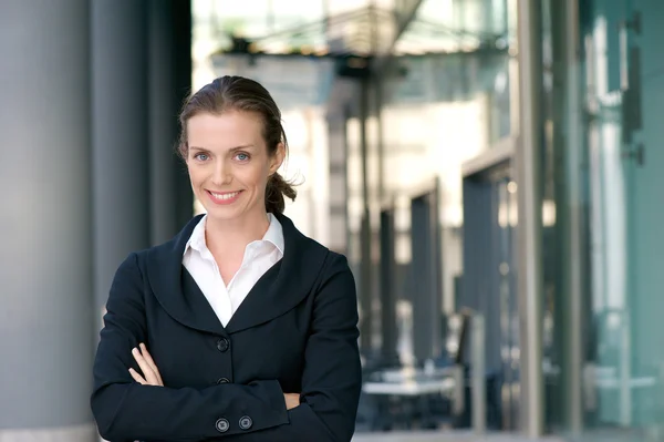 Femme d'affaires confiante souriant avec les bras croisés — Photo