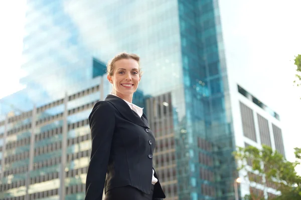 Mujer de negocios moderna sonriendo y caminando fuera —  Fotos de Stock