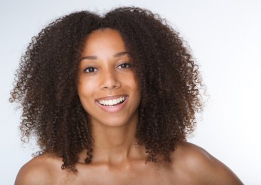 Kıvırcık saçlı gülümseyen genç Afro-Amerikan kadın