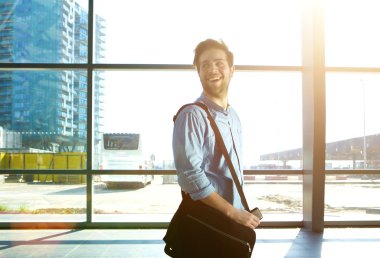 Mutlu adam çanta ile istasyonda yürüyüş