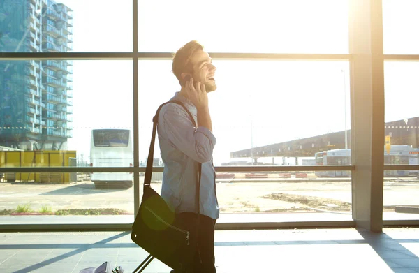 Uomo sorridente che cammina e parla sul cellulare alla stazione — Foto Stock