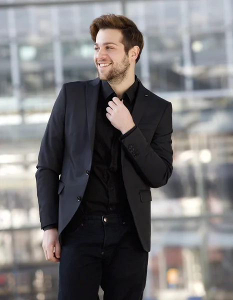 Уверенный молодой человек, улыбающийся в черной одежде — стоковое фото