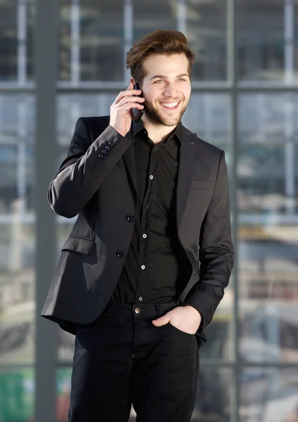 Glücklicher junger moderner Mann, der mit dem Handy spricht — Stockfoto