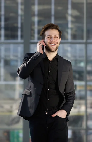 Šťastný mladý muž chodí a mluví na mobilním telefonu — Stock fotografie