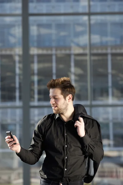 Selbstbewusster junger Mann liest SMS auf Handy — Stockfoto