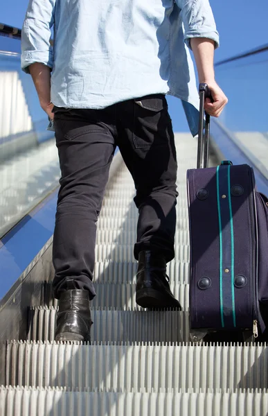 Costas de homem andando escada rolante com saco de viagem — Fotografia de Stock