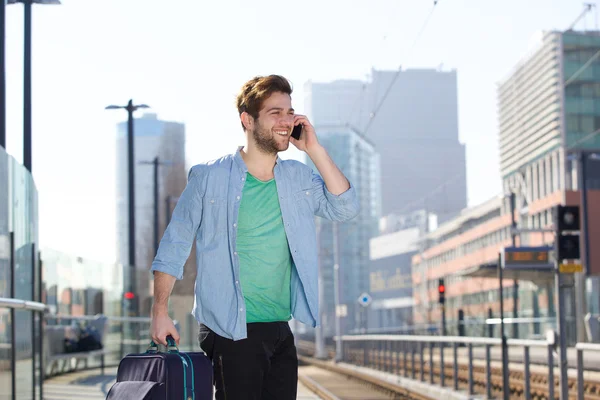 A vonat állomás emelvény-val mozgatható telefon, vidám fiatalember — Stock Fotó