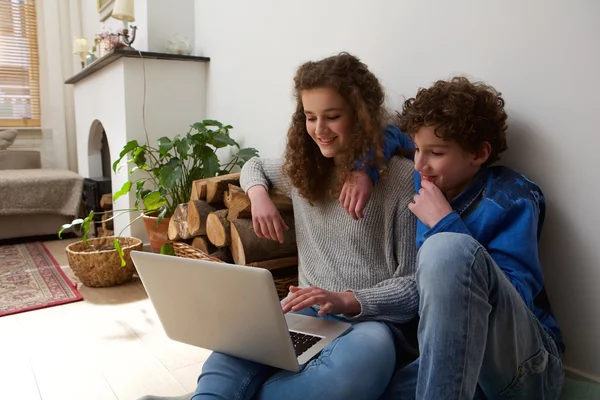 Boldog testvérpár használ laptop otthon együtt — Stock Fotó